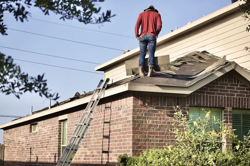 Professional roofer working on a residential roof in Middleton Colony